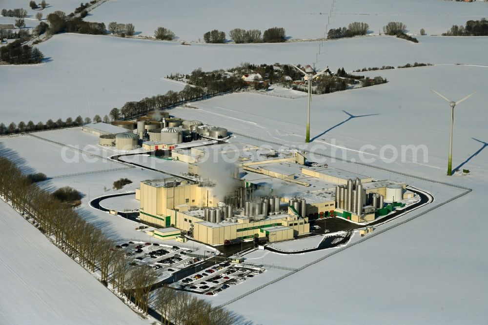 Klatzow from the bird's eye view: Wintry snowy buildings and production halls on the food manufacturer's premises DMK Deutsches Milchkontor GmbH in Klatzow in the state Mecklenburg - Western Pomerania, Germany