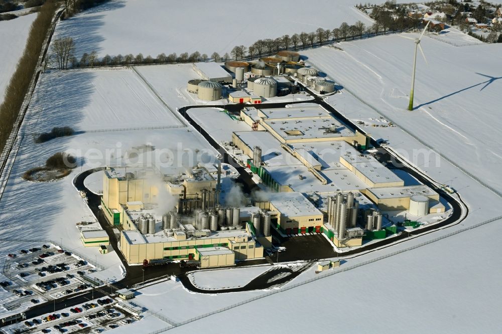 Klatzow from the bird's eye view: Wintry snowy buildings and production halls on the food manufacturer's premises DMK Deutsches Milchkontor GmbH in Klatzow in the state Mecklenburg - Western Pomerania, Germany