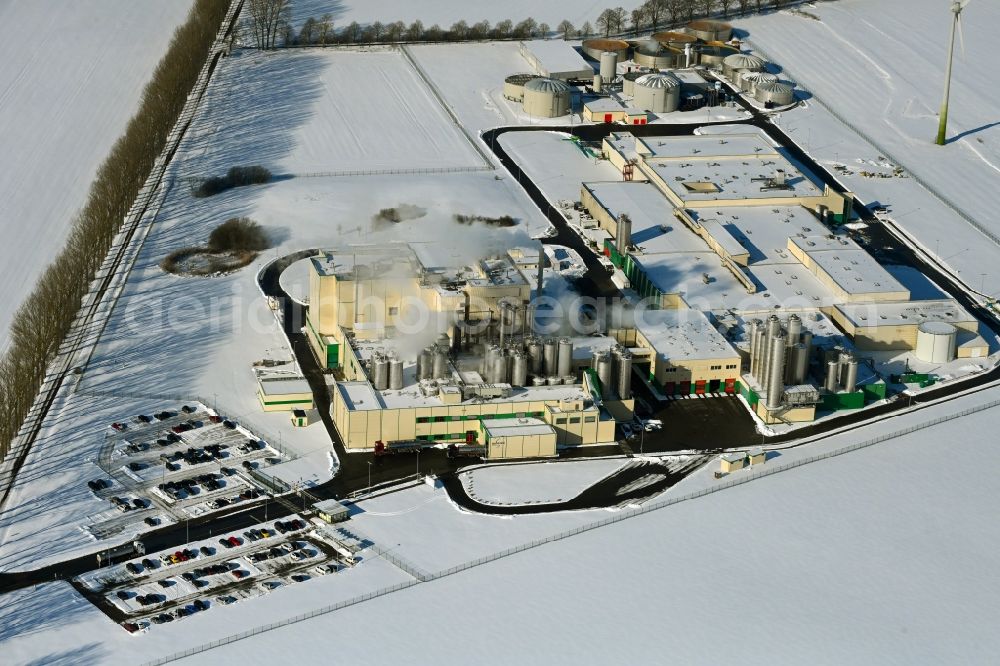 Klatzow from the bird's eye view: Wintry snowy buildings and production halls on the food manufacturer's premises DMK Deutsches Milchkontor GmbH in Klatzow in the state Mecklenburg - Western Pomerania, Germany