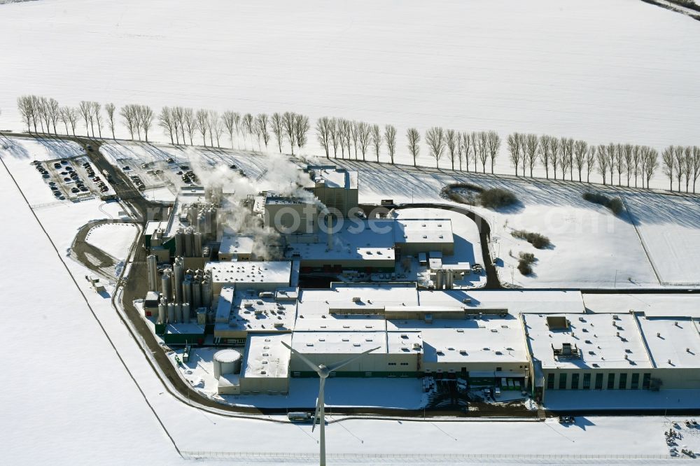 Klatzow from the bird's eye view: Wintry snowy buildings and production halls on the food manufacturer's premises DMK Deutsches Milchkontor GmbH in Klatzow in the state Mecklenburg - Western Pomerania, Germany