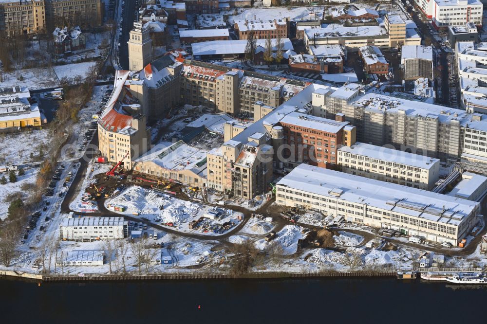 Aerial photograph Berlin - Wintry snowy new building construction site in the industrial park Behrensbau on Behrens- Ufer of Spree on street Ostendstrasse in the district Oberschoeneweide in the district Schoeneweide in Berlin, Germany