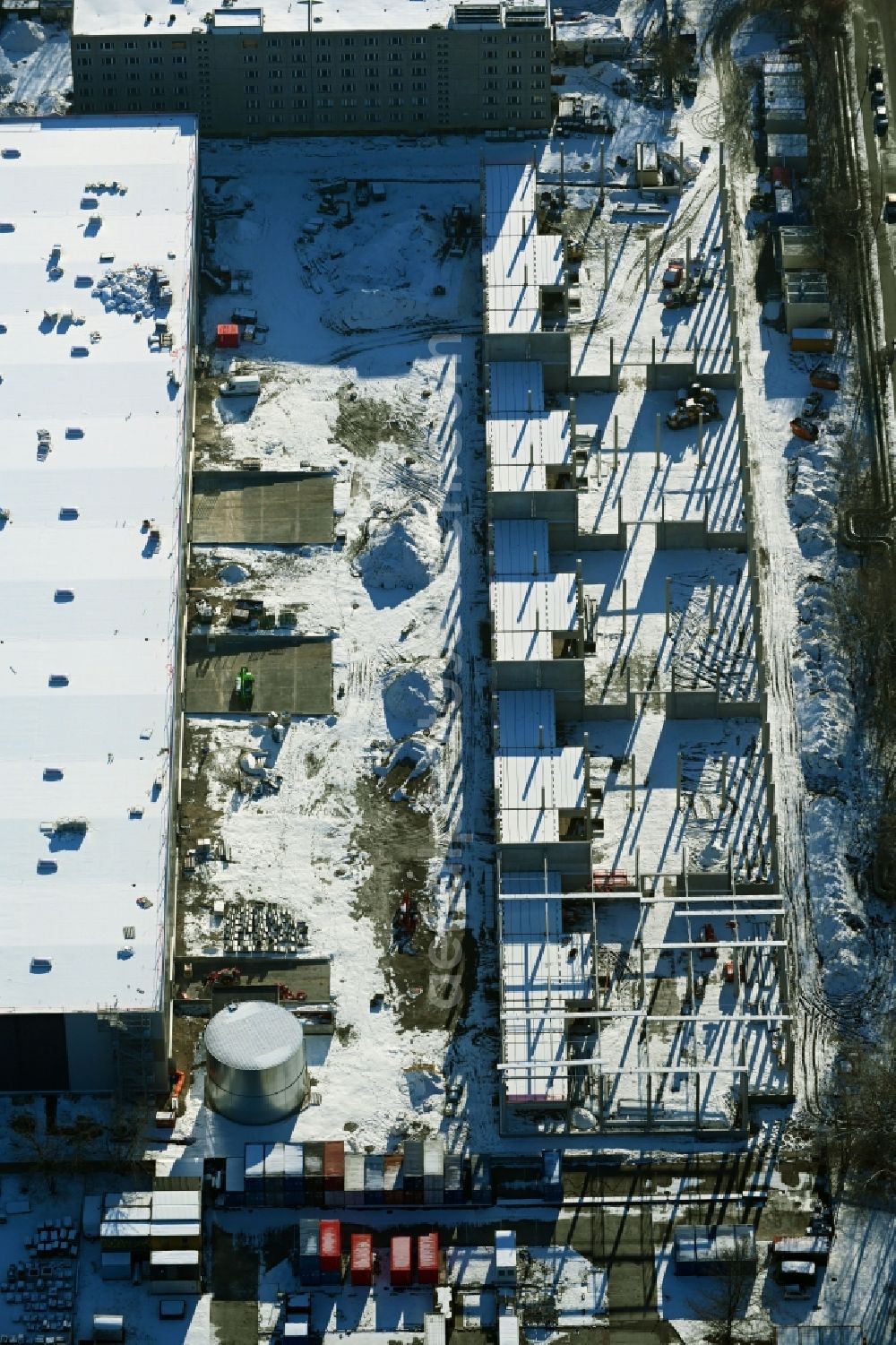 Berlin from above - Wintry snowy new building construction site in the industrial park Wollenberger Strasse in the district Hohenschoenhausen in Berlin, Germany