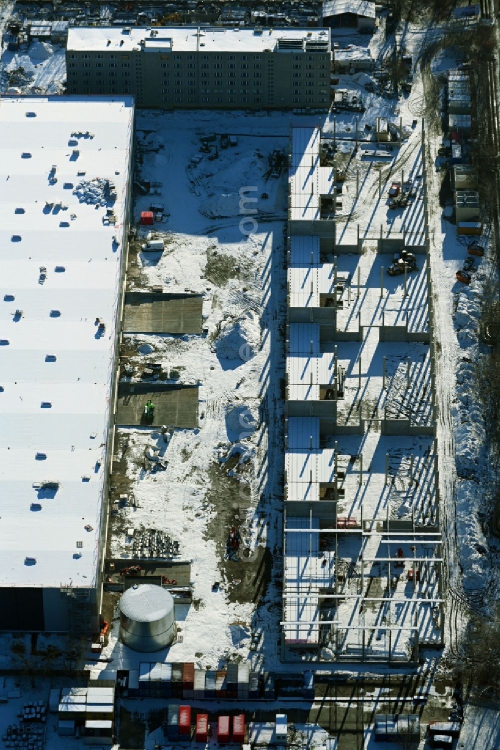 Berlin from the bird's eye view: Wintry snowy new building construction site in the industrial park Wollenberger Strasse in the district Hohenschoenhausen in Berlin, Germany