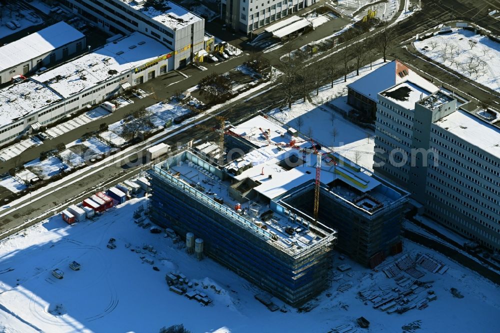 Berlin from above - Wintry snowy construction site to build a new office and commercial building on Beilsteiner Strasse in the district Marzahn in Berlin, Germany