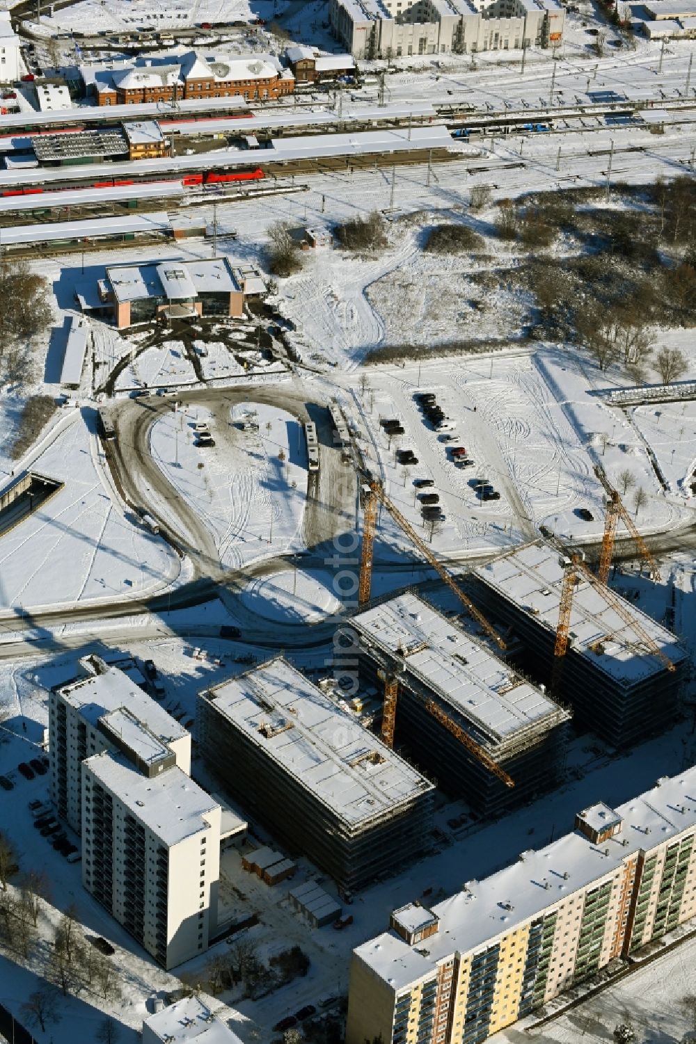 Aerial photograph Rostock - Wintry snowy construction site to build a new office and commercial building on Bahnhofsvorplatz in the district Suedstadt in Rostock in the state Mecklenburg - Western Pomerania, Germany