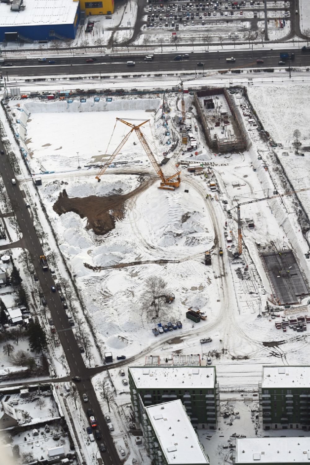 Berlin from the bird's eye view: Wintry snowy construction site to build a new multi-family residential complex Weisse Taube between Ferdinand-Schultze-Strasse, Plauener Strasse and Landsberger Allee in the district Hohenschoenhausen in Berlin, Germany