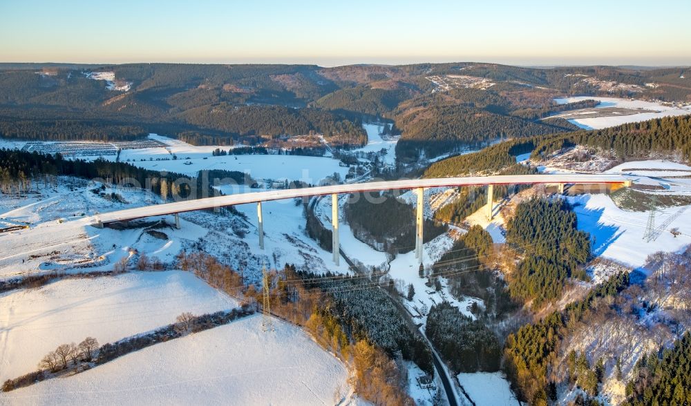 Bestwig from the bird's eye view: Wintry snowy viaduct Nuttlar under construction overlooking the municipality Bestwig in North Rhine-Westphalia