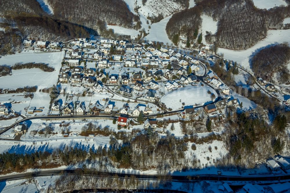 Brilon from the bird's eye view: Wintry snowy Town View of the streets and houses of the residential areas in the district Messinghausen in Brilon in the state North Rhine-Westphalia