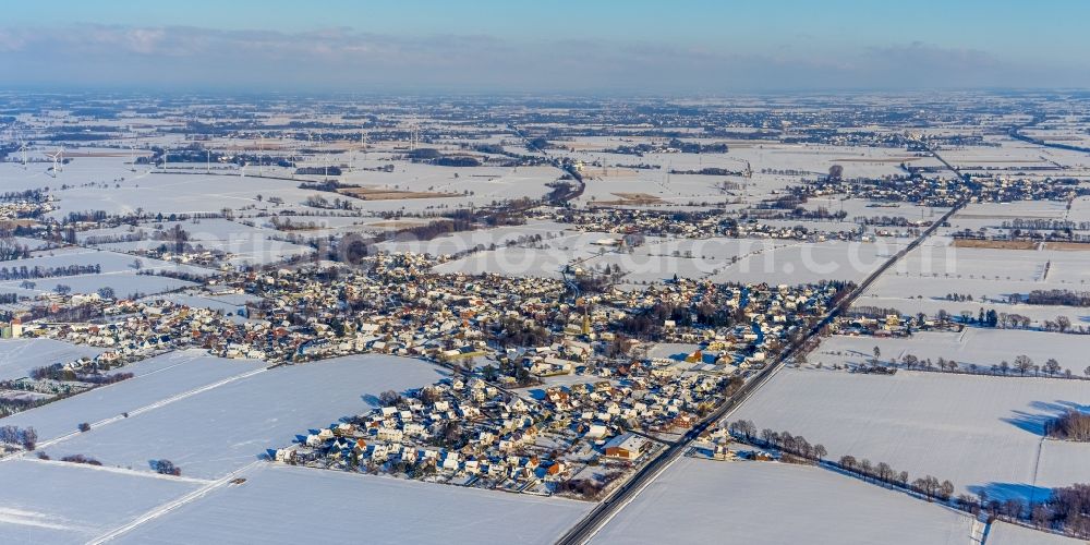 Aerial photograph Westönnen - Wintry snowy village view on the edge of agricultural fields and land in Westoennen in the state North Rhine-Westphalia, Germany