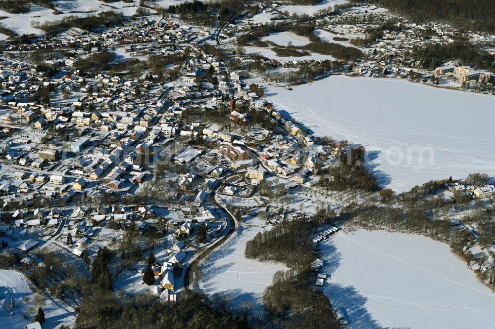 Aerial photograph Feldberg - Wintry snowy village on the banks of the area lake of Feldberger Seenlandschaft in Feldberg in the state Mecklenburg - Western Pomerania, Germany