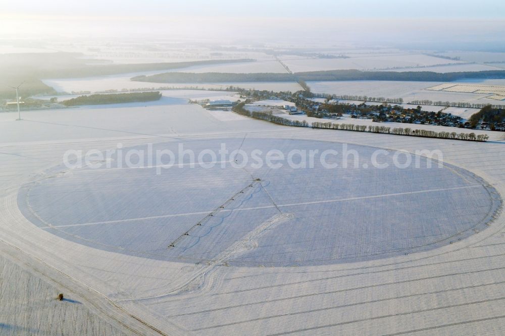 Aerial image Sülte - Wintry snowy circular round arch of a pivot irrigation system on agricultural fields in Suelte in the state Mecklenburg - Western Pomerania, Germany