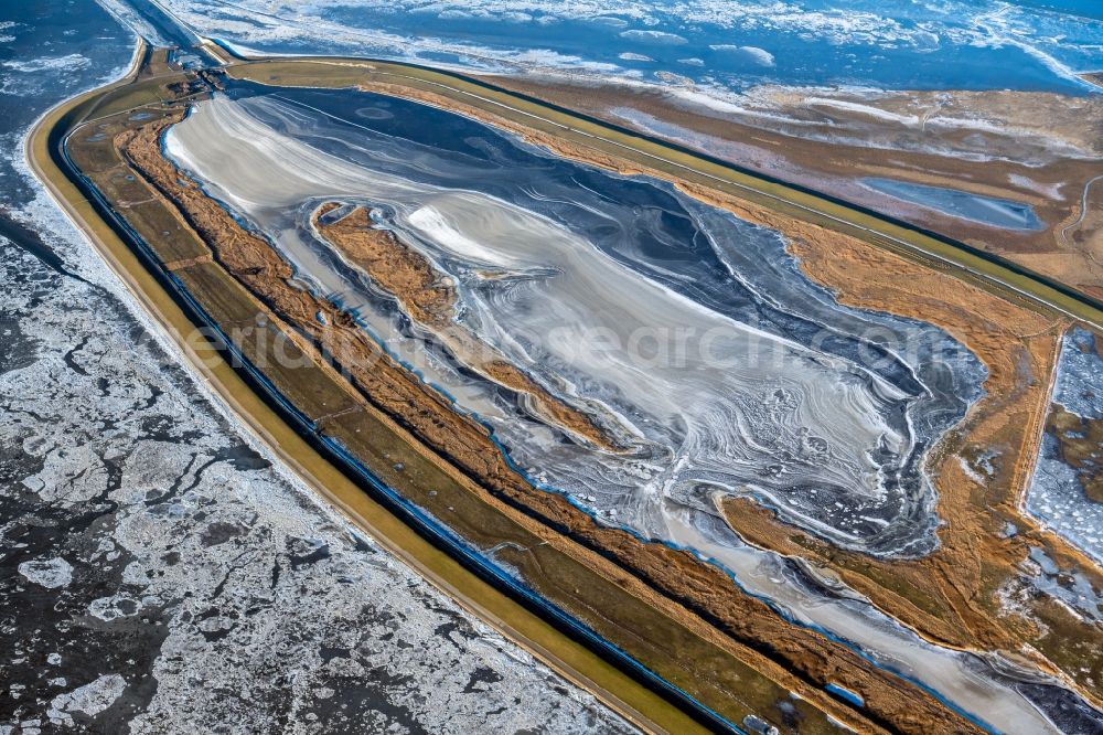 Krummhörn from the bird's eye view: Wintry snowy retention basin and water storage Leyhoern in Krummhoern in the state Lower Saxony, Germany