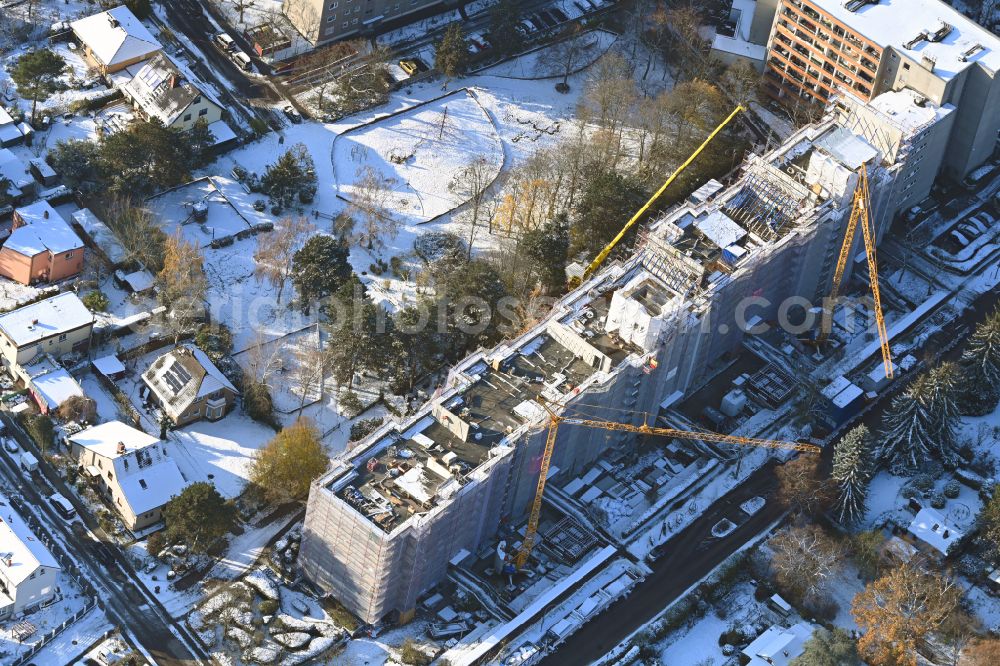 Aerial photograph Berlin - Wintry snowy construction site for the renovation and modernization of the high-rise buildings in the residential area on street Ortolanweg in the district Buckow in Berlin, Germany