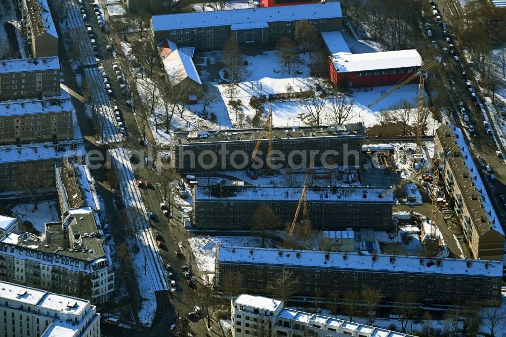 Aerial image Berlin - Wintry snowy refurbishment and modernization of a terraced apartment complex between Wolfshagener Strasse and Stiftsweg in the district Pankow in Berlin, Germany