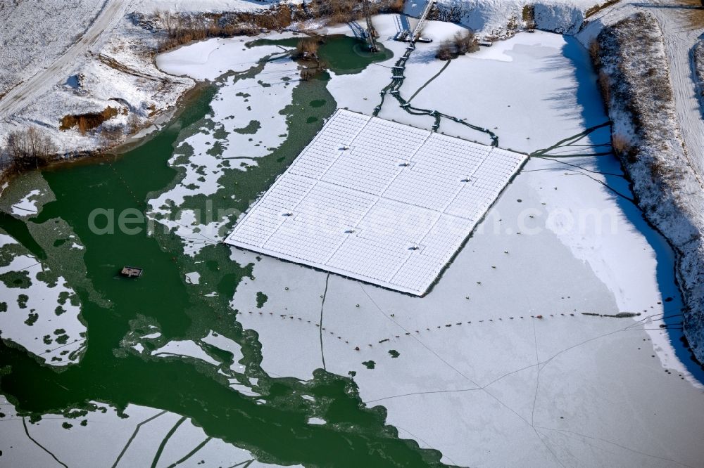 Aerial photograph Dettelbach - Wintry snowy floating solar power plant and panels of photovoltaic systems on the surface of the water on Dettelbacher Baggersee in Dettelbach in the state Bavaria, Germany