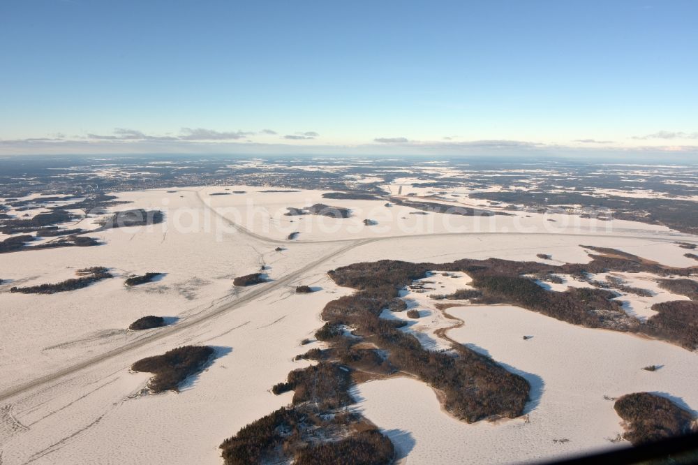 Lake Mälaren from the bird's eye view: Wintery snowy shore area scenery of Lake Maelaren with free shipping lanes in Vaestmanland County, Sweden