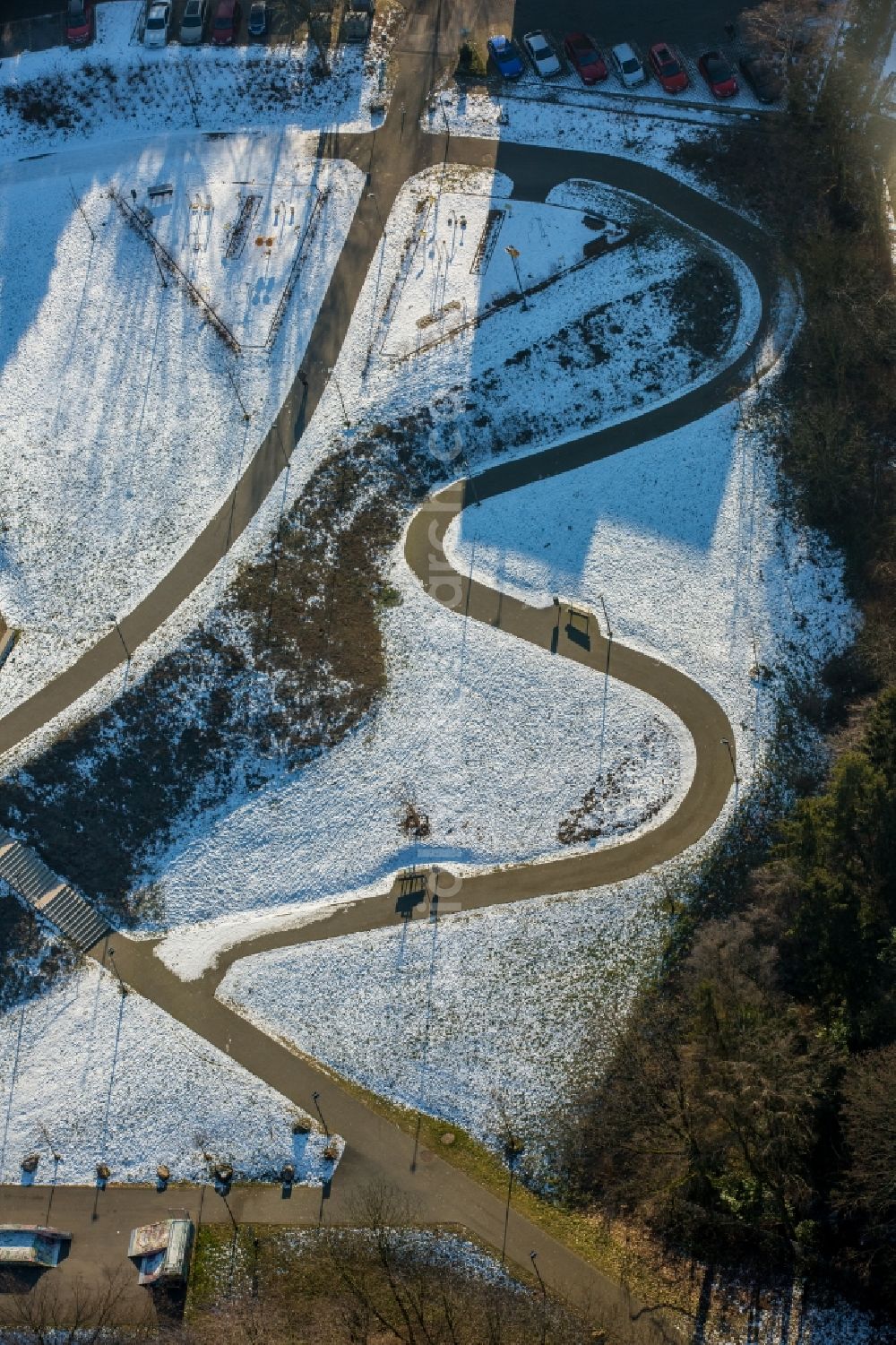 Heiligenhaus from the bird's eye view: Wintry snowy Serpentine-shaped curve of a road guide in Heiligenhaus in the state North Rhine-Westphalia