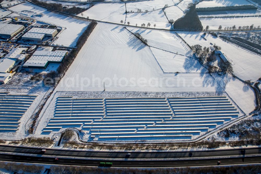 Aerial image Enste - Wintry snowy Rows of panels of a solar power plant and photovoltaic system on Autobahn BAB A46 in Enste at Sauerland in the state North Rhine-Westphalia, Germany