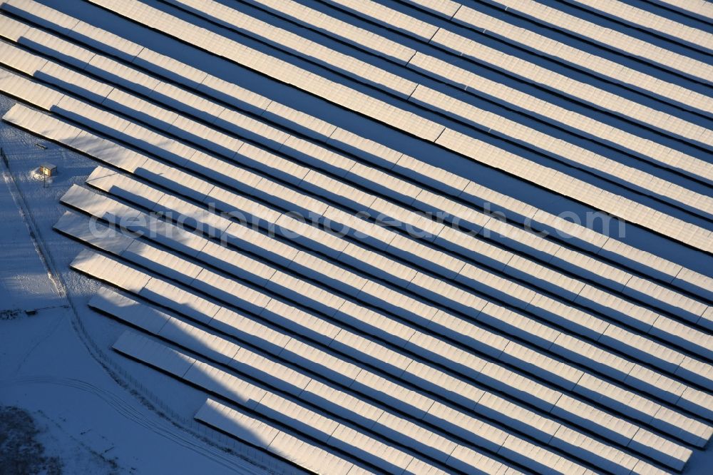 Aerial photograph Werneuchen - Wintry snowy Panel rows of photovoltaic and solar farm or solar power plant in Werneuchen in the state Brandenburg