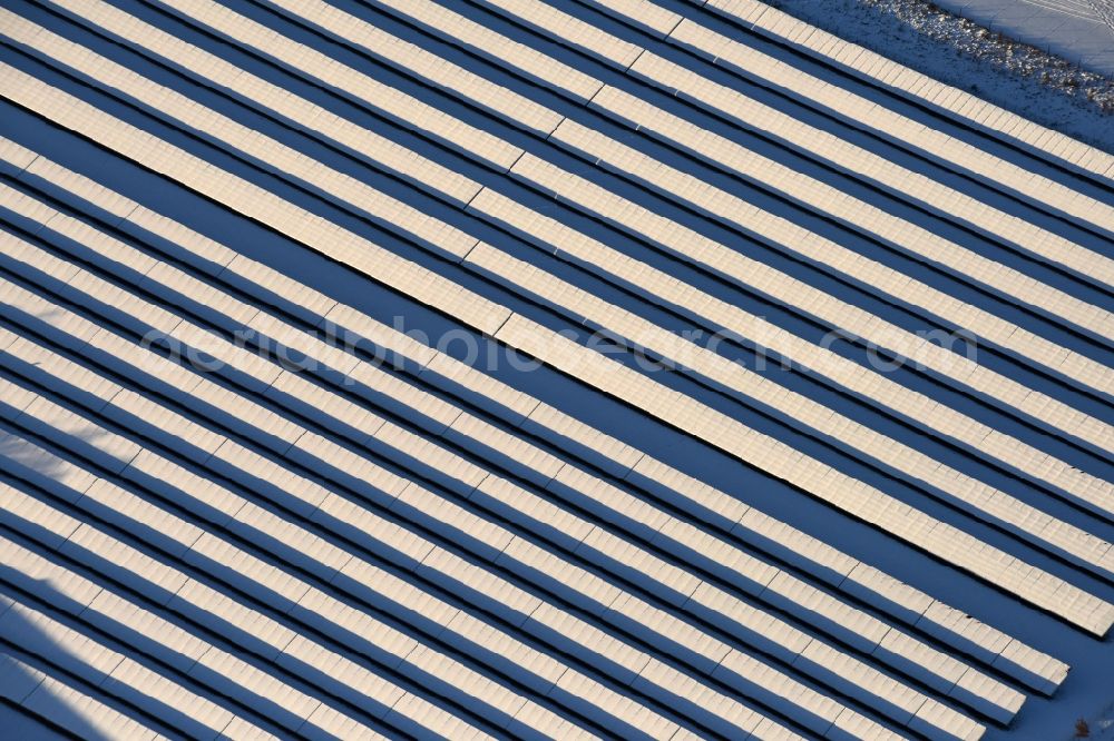 Werneuchen from above - Wintry snowy Panel rows of photovoltaic and solar farm or solar power plant in Werneuchen in the state Brandenburg