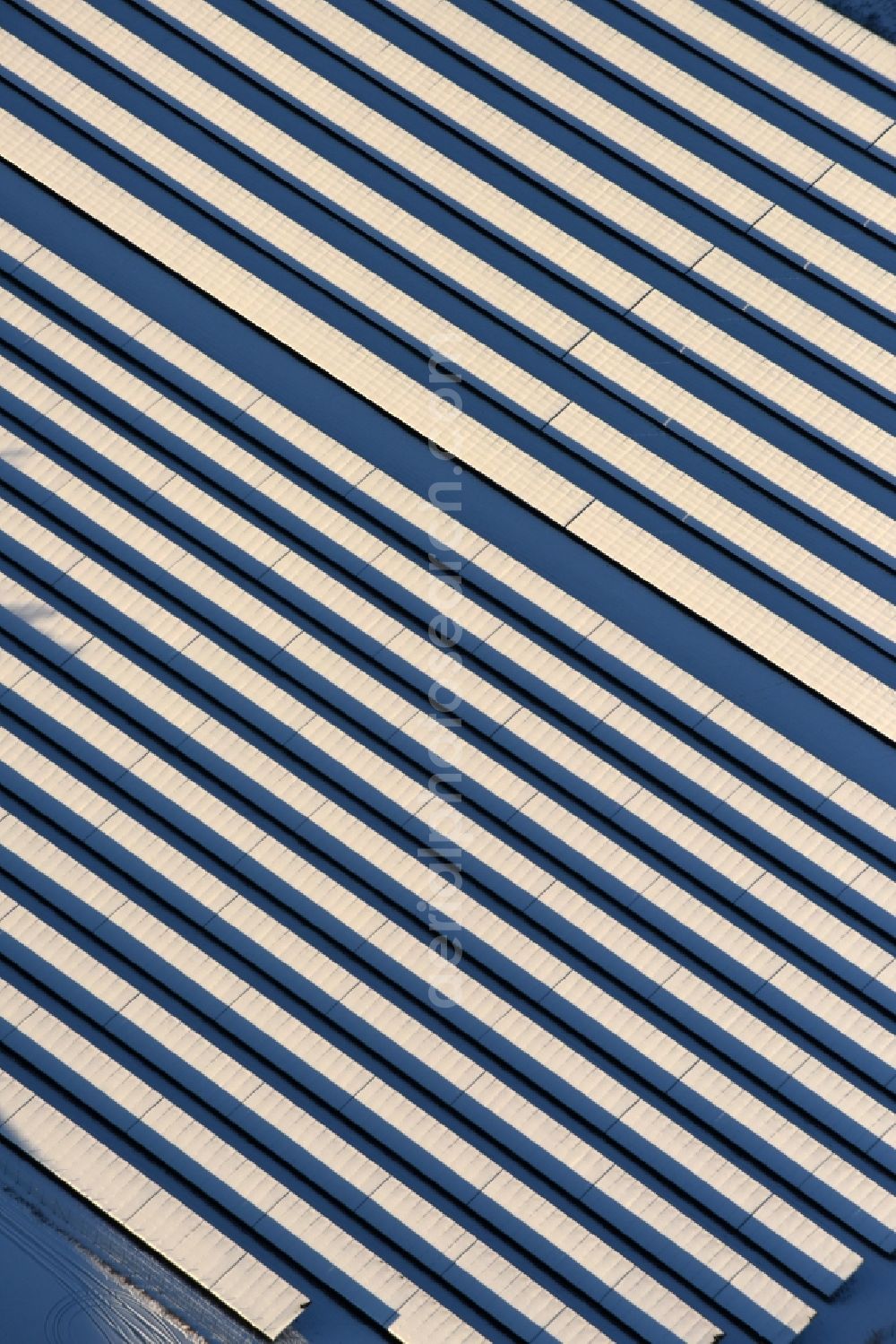 Werneuchen from the bird's eye view: Wintry snowy Panel rows of photovoltaic and solar farm or solar power plant in Werneuchen in the state Brandenburg