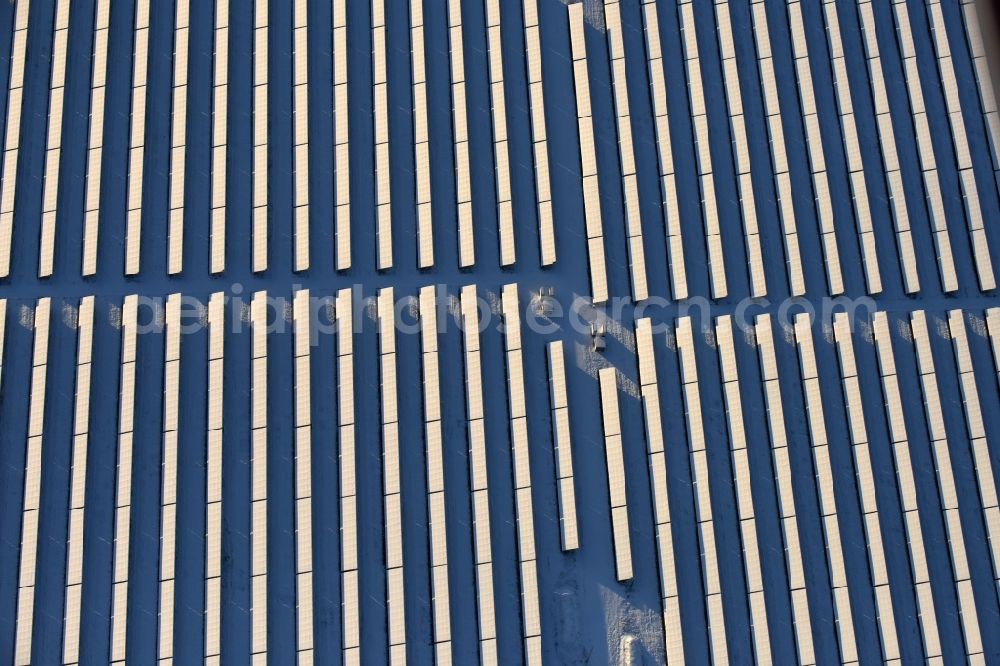 Aerial photograph Werneuchen - Wintry snowy Panel rows of photovoltaic and solar farm or solar power plant in Werneuchen in the state Brandenburg