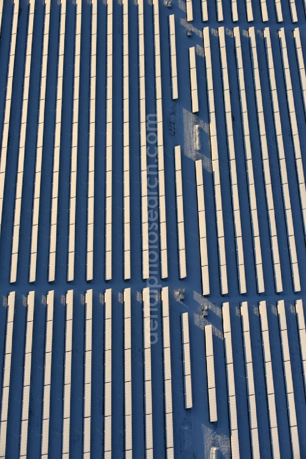 Werneuchen from above - Wintry snowy Panel rows of photovoltaic and solar farm or solar power plant in Werneuchen in the state Brandenburg