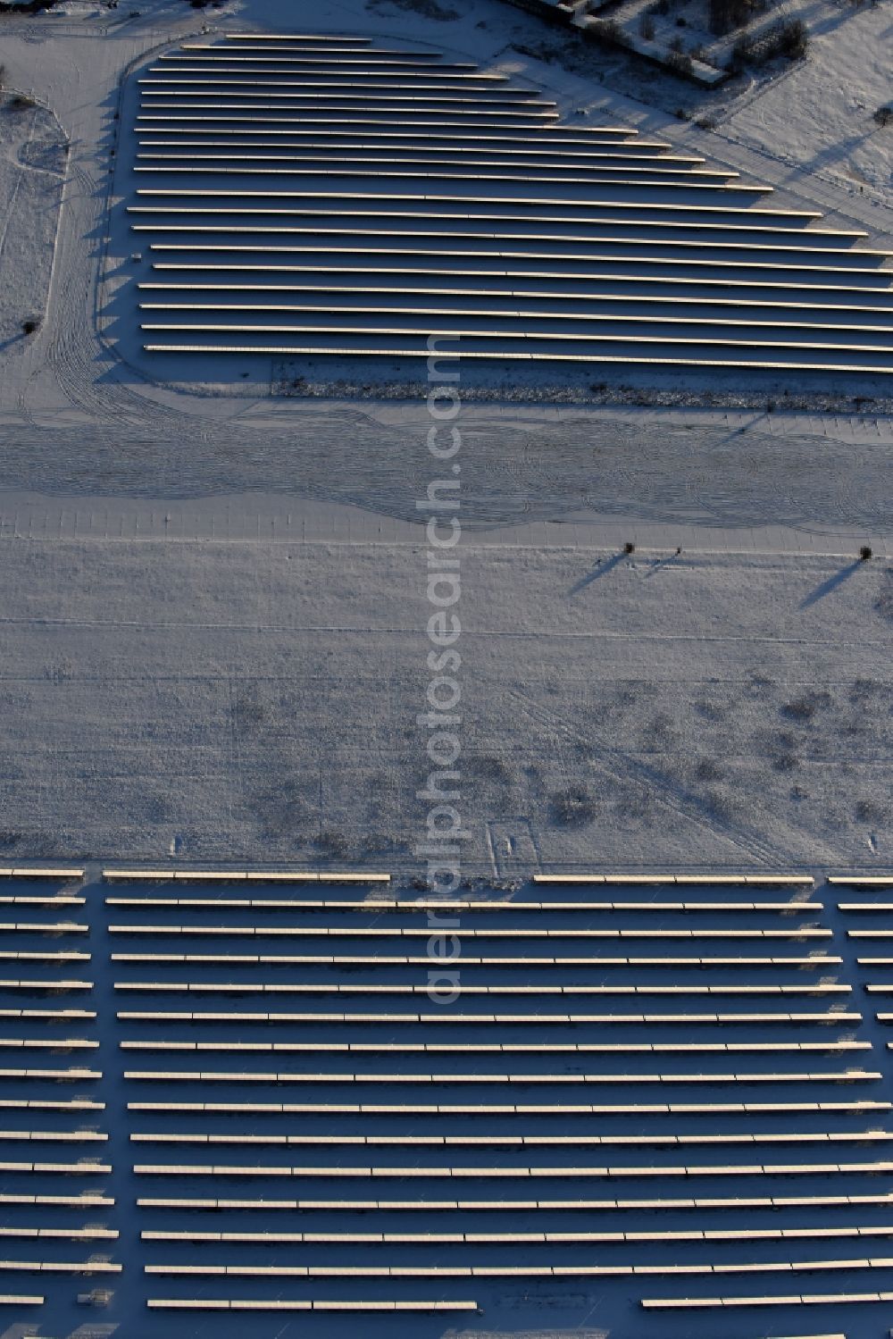 Aerial photograph Werneuchen - Wintry snowy Panel rows of photovoltaic and solar farm or solar power plant in Werneuchen in the state Brandenburg