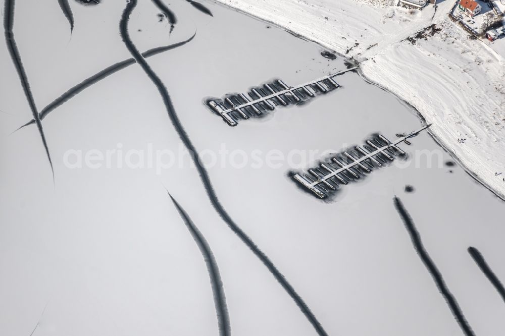 Aerial photograph Delecke - Wintry snow-covered sports boat moorings and boat berths on the shore area of a??a??the frozen Moehnsee in Delecke in the state North Rhine-Westphalia, Germany