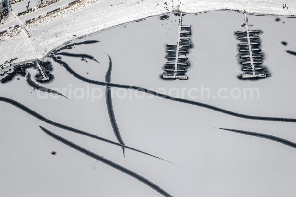 Aerial image Delecke - Wintry snow-covered sports boat moorings and boat berths on the shore area of a??a??the frozen Moehnsee in Delecke in the state North Rhine-Westphalia, Germany