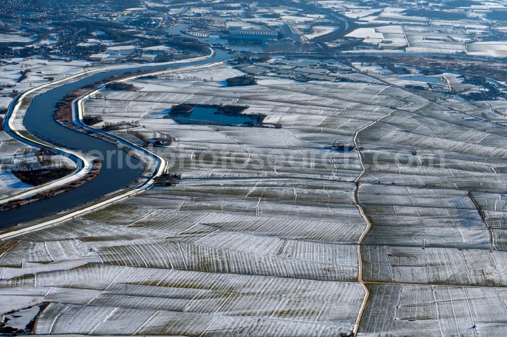 Weener from above - Wintry snowy structures on agricultural fields on the course of the Ems in Weener in the state Lower Saxony, Germany