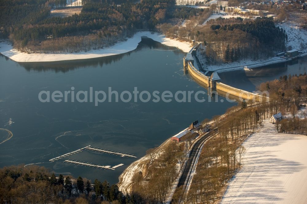 Möhnesee from the bird's eye view: Wintry snowy Dam and shore areas at the lake Moehnesee in the state North Rhine-Westphalia