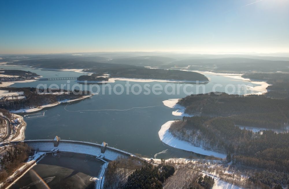 Aerial photograph Möhnesee - Wintry snowy Dam and shore areas at the lake Moehnesee in the state North Rhine-Westphalia