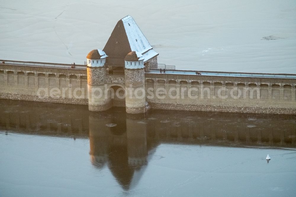 Möhnesee from the bird's eye view: Wintry snowy Dam and shore areas at the lake Moehnesee in the state North Rhine-Westphalia