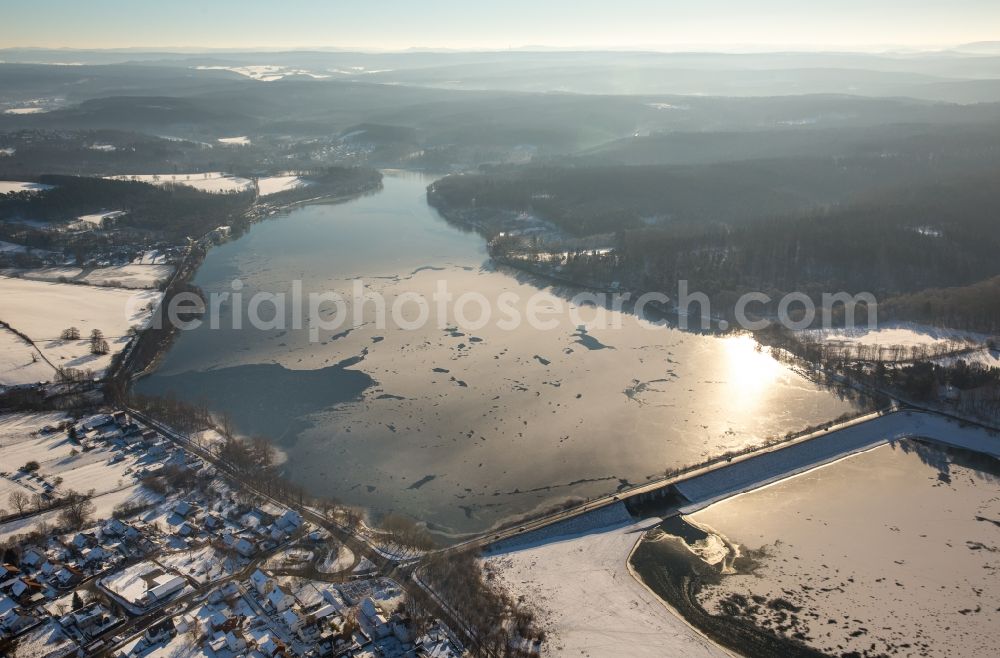 Möhnesee from the bird's eye view: Wintry snowy Dam and shore areas at the lake Moehnesee in the state North Rhine-Westphalia