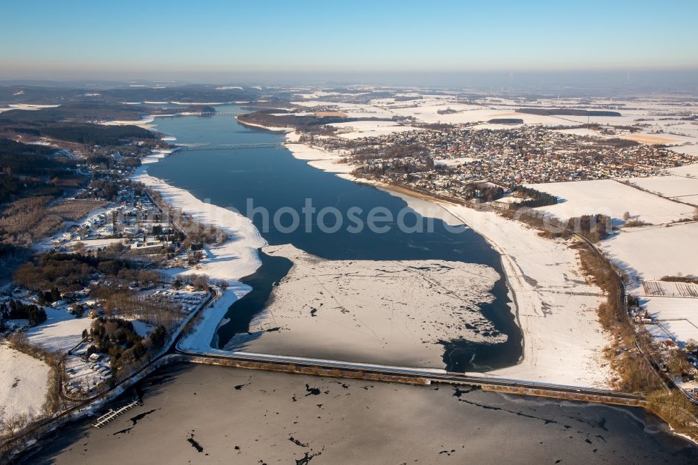 Aerial photograph Möhnesee - Wintry snowy Dam and shore areas at the lake Moehnesee in the state North Rhine-Westphalia