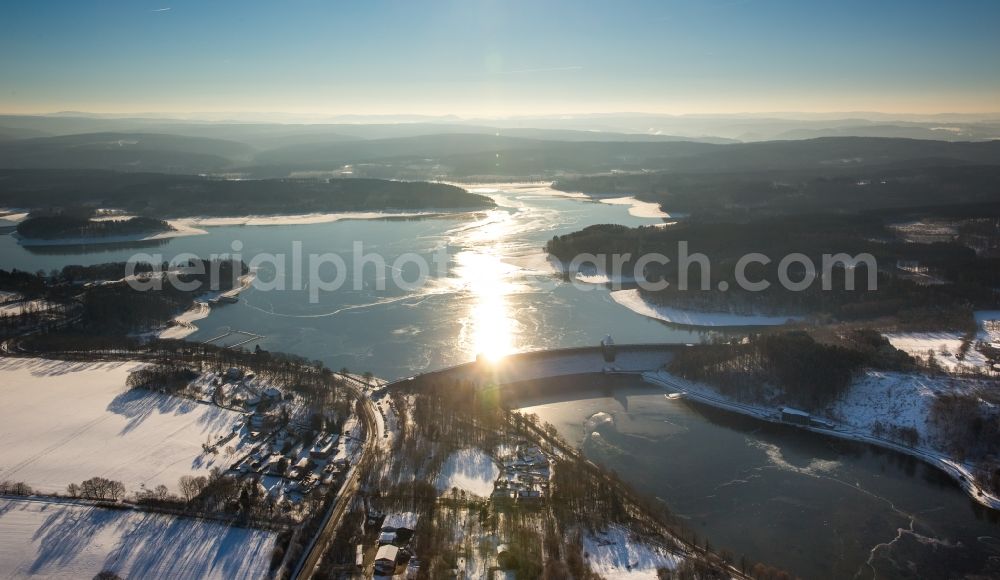 Möhnesee from the bird's eye view: Wintry snowy Dam and shore areas at the lake Moehnesee in the state North Rhine-Westphalia