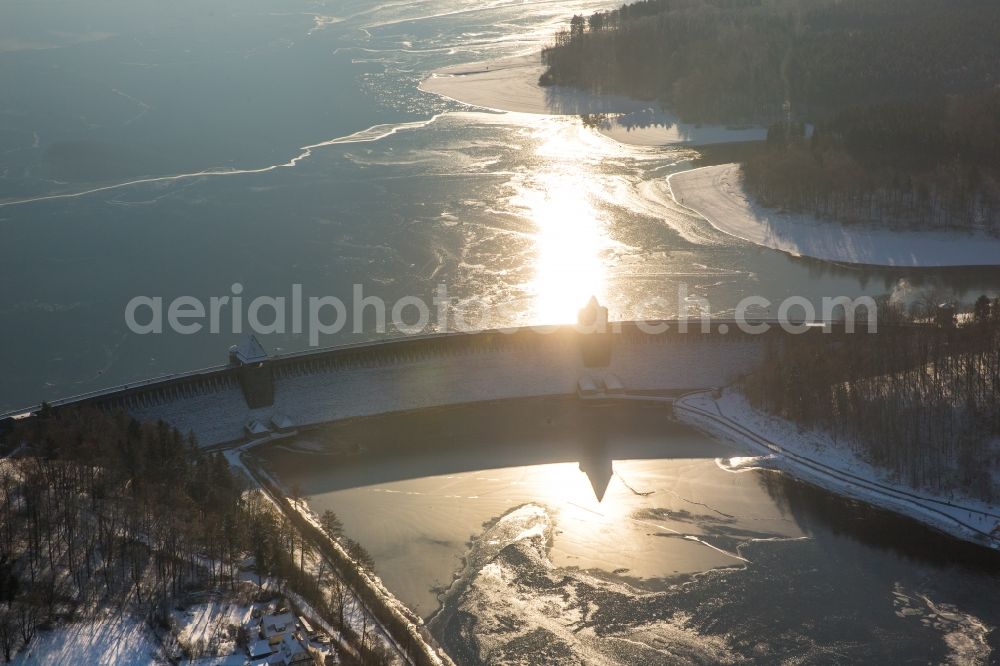 Möhnesee from the bird's eye view: Wintry snowy Dam and shore areas at the lake Moehnesee in the state North Rhine-Westphalia