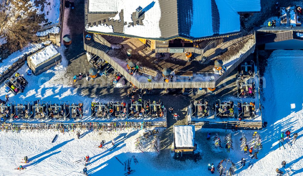 Winterberg from the bird's eye view: Wintry snowy tables and benches of open-air restaurant Restaurant Bei Moeppi on street In der Buere in Winterberg at Sauerland in the state North Rhine-Westphalia, Germany