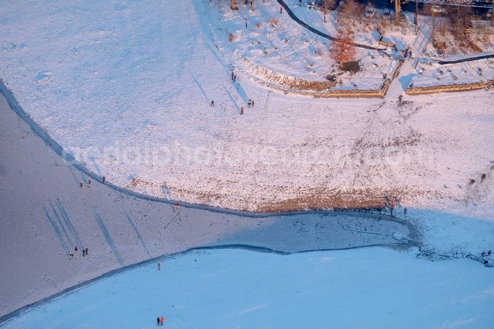 Aerial image Möhnesee - Stroller on the wintry snowy and ice-capped bank areas of the Moehnesee in Moehnesee in the federal state North Rhine-Westphalia