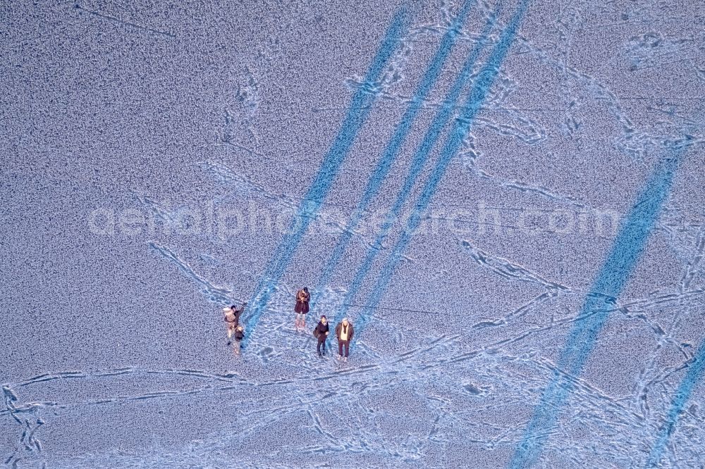 Möhnesee from above - Stroller on the wintry snowy and ice-capped bank areas of the Moehnesee in Moehnesee in the federal state North Rhine-Westphalia