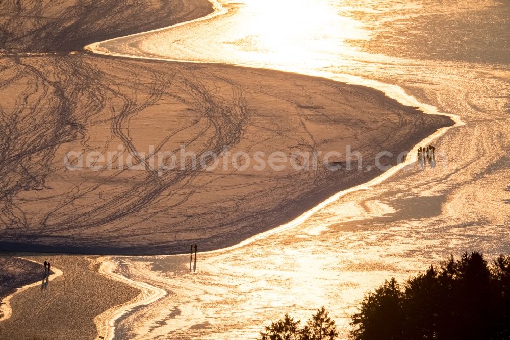 Aerial image Möhnesee - Stroller on the wintry snowy and ice-capped bank areas of the Moehnesee in Moehnesee in the federal state North Rhine-Westphalia