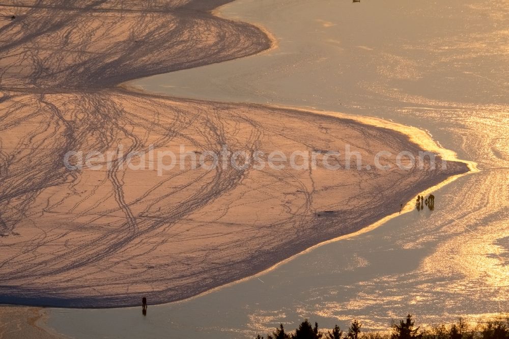 Möhnesee from the bird's eye view: Stroller on the wintry snowy and ice-capped bank areas of the Moehnesee in Moehnesee in the federal state North Rhine-Westphalia