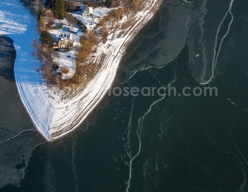 Delecke from the bird's eye view: Wintry snowy Riparian areas on the lake area of Moehnesee in Delecke in the state North Rhine-Westphalia