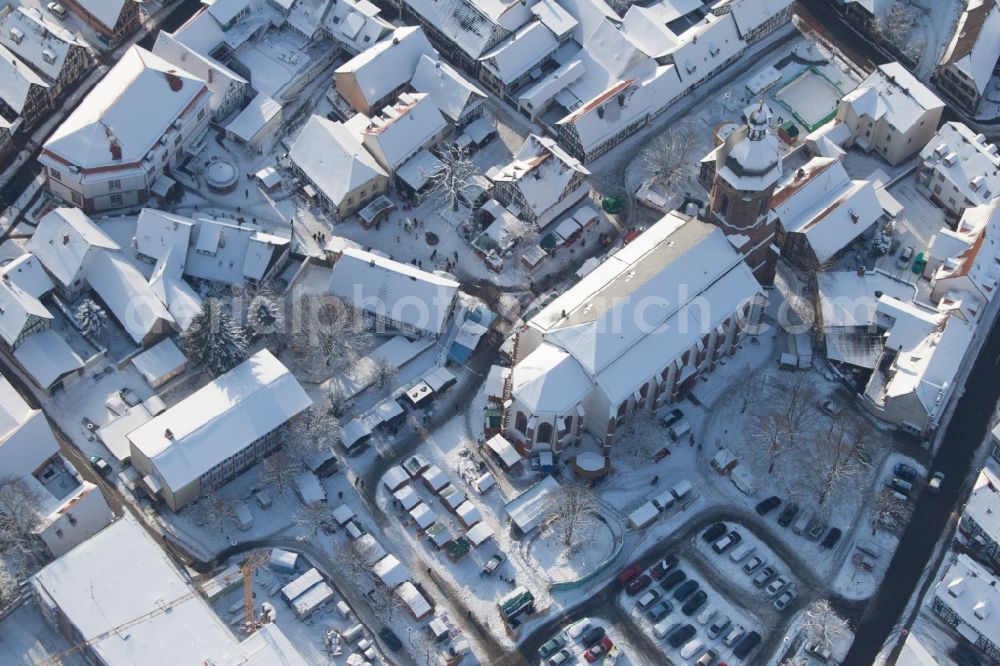 Kandel from above - Wintry snowy Christmassy market event grounds and sale huts and booths on market place around tha church Sankt Georgskirche in Kandel in the state Rhineland-Palatinate, Germany