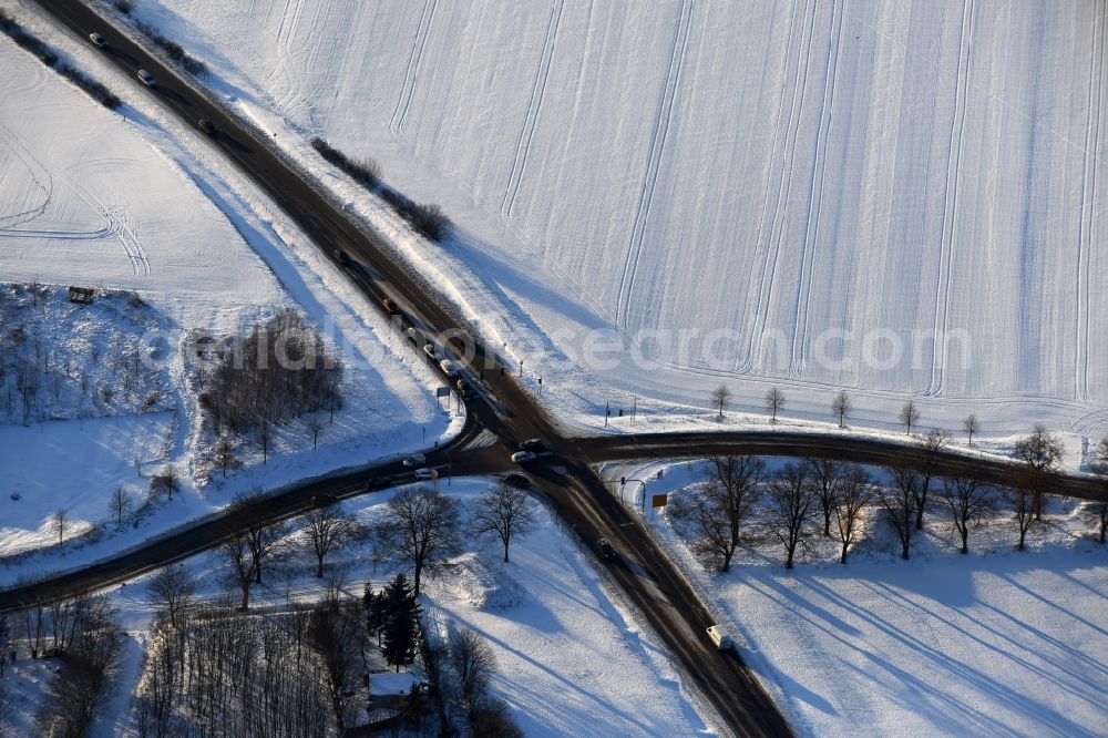 Fredersdorf-Vogelsdorf from the bird's eye view: Wintry snowy road over the crossroads Fredersdorfer Chaussee - road L33 in the district Fredersdorf in Fredersdorf-Vogelsdorf in the state Brandenburg