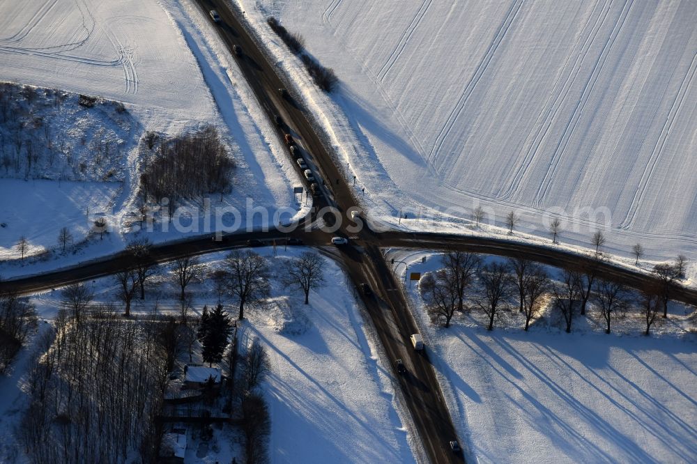 Aerial image Fredersdorf-Vogelsdorf - Wintry snowy road over the crossroads Fredersdorfer Chaussee - road L33 in the district Fredersdorf in Fredersdorf-Vogelsdorf in the state Brandenburg