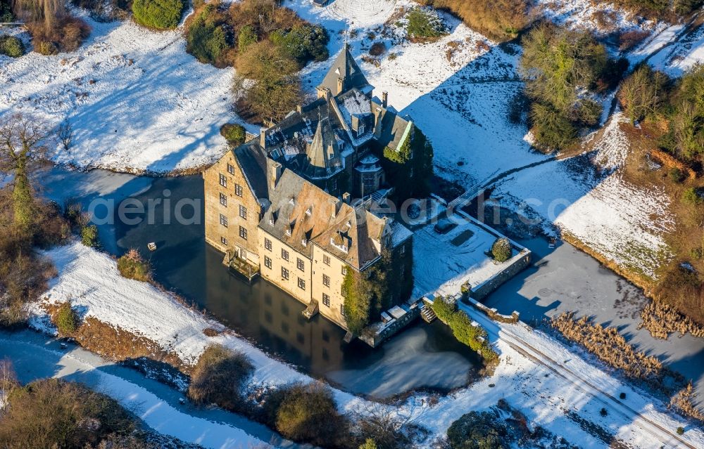 Neheim from the bird's eye view: Wintry snowy building and castle park systems of water castle Hoellinghofen in Neheim in the state North Rhine-Westphalia