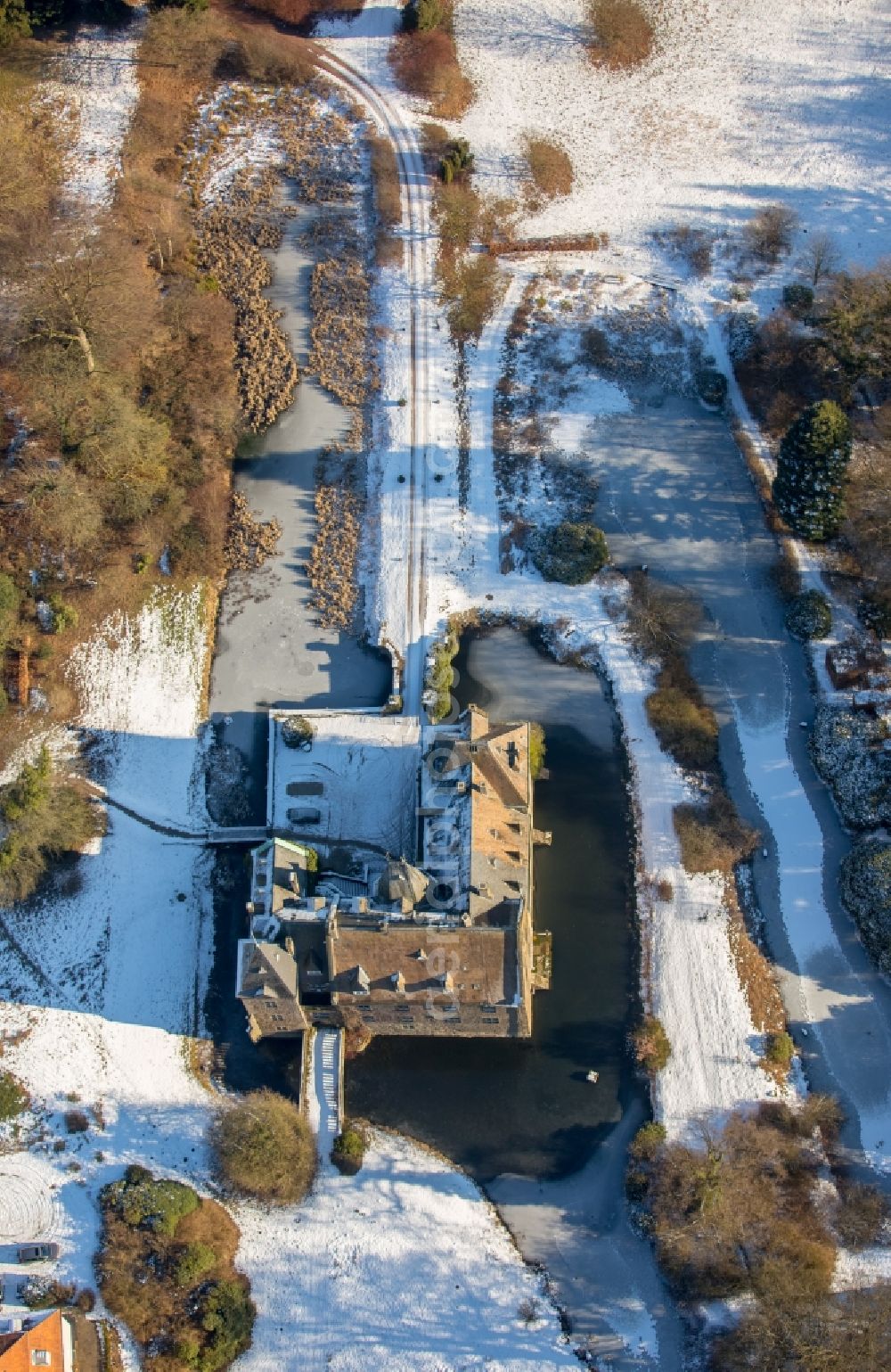 Neheim from above - Wintry snowy building and castle park systems of water castle Hoellinghofen in Neheim in the state North Rhine-Westphalia