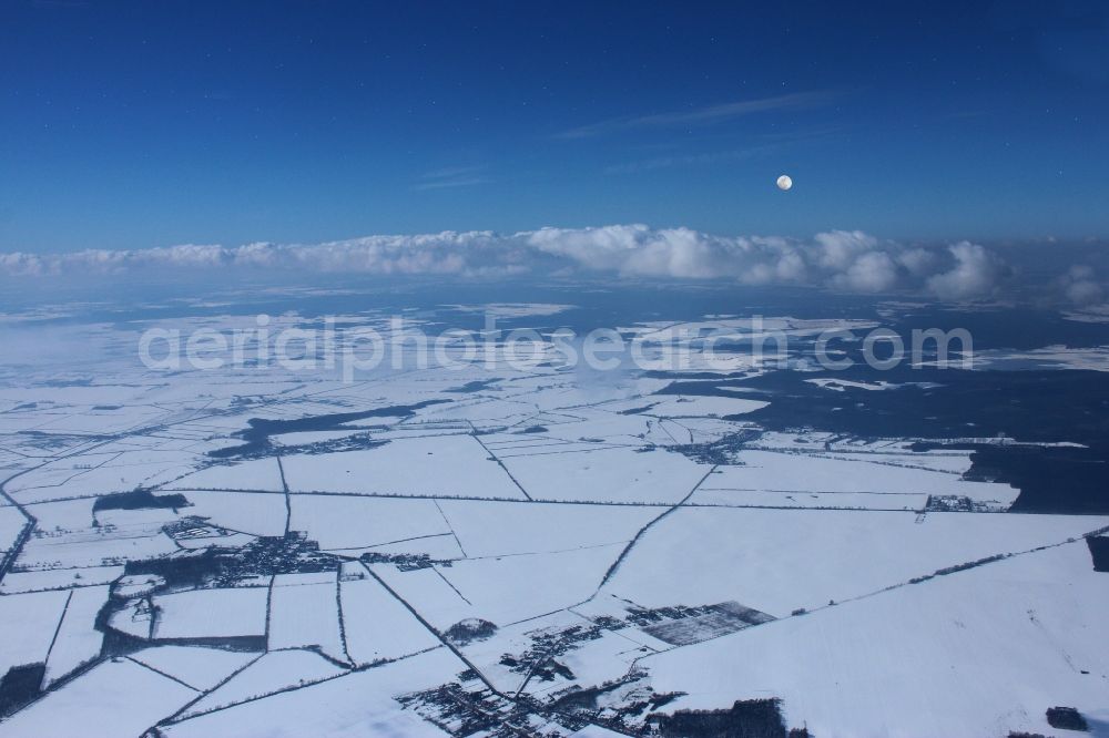 Aerial photograph Fehrbellin - Wintry snowy weather conditions with cloud formation - on blue Sky in Fehrbellin in the state Brandenburg